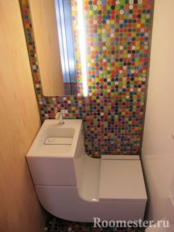 Pequeño inodoro con inodoro moderno y mosaico brillante.