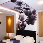 El diseño del techo en el dormitorio con papel tapiz con perspectiva.