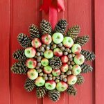 Conos y manzanas en una corona de flores