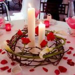Decoración de mesa con velas y pétalos de rosa.