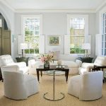 Una habitación con muebles blancos y una mesa marrón.
