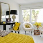 Dormitorio blanco con decoración amarilla.