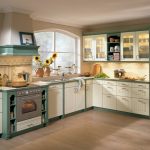 Cocina con muebles blancos y verdes.