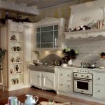 Estante con reloj y flores en la cocina.