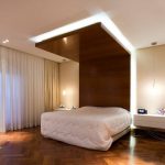 Área de madera natural con luz sobre la cama.