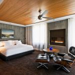 Chimenea, mesa y silla cerca de la cama.