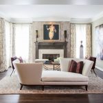 Muebles blancos y una foto encima de la chimenea.