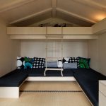 Sofás y cama en el segundo nivel con una escalera de cuerda.