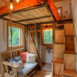 Cocina y comedor en una habitación con cama en el segundo piso.
