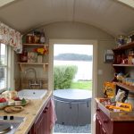 Pequeña cocina con mesa, estanterías y armario.