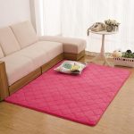 Alfombra rosa cerca del sofá blanco