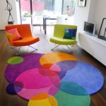 Interior con sillas de colores y alfombra.