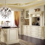 Muebles blancos con motivos dorados en la cocina.