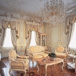 Interior blanco con sofás antiguos y una mesa.