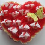 Decoración Rafaeloc en forma de corazón con arcos y mariposa.