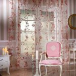 Sillón rosa y cortinas en el interior.