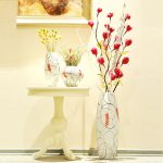 Una mesa con flores debajo de un cuadro en la pared