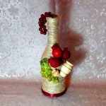 Botella con decoración de fruta y jarra