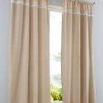 Cortinas beige en un interior gris.