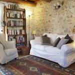 Muebles blancos y paredes de piedra.