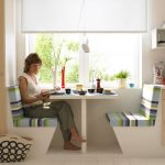 Una mesa y sillas junto a la ventana.