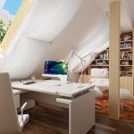Sillón y mesa con computadora junto a la ventana