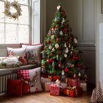 Almohadas y árbol de navidad junto a la ventana