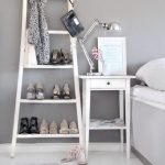 Estante con zapatos junto a la cama