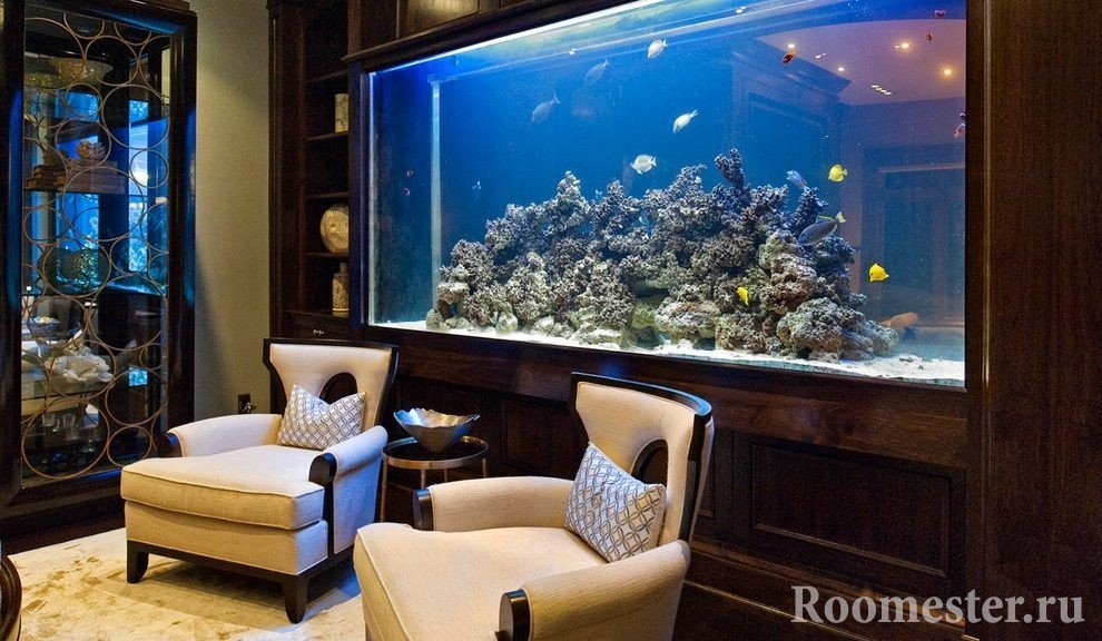 Mga armchair at isang lamesa na malapit sa aquarium