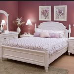 Interior de dormitorio lila con muebles blancos