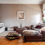 Muebles blancos y paredes de café en la sala de estar.