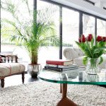 Sillón y flor junto a la ventana.