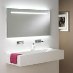 Espejo iluminado sobre el lavabo