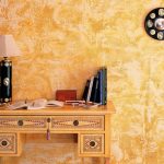 Mesa con lámpara junto a la pared.