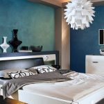 Dormitorio con paredes azules y muebles blancos.