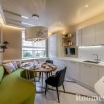 Sofá verde claro en el interior de una cocina blanca