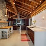Muro de piedra y techo de madera en la cocina.