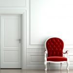 Sillón rojo en un interior blanco.