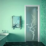 Puerta de cristal con motivos en el baño.