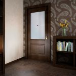Papel pintado oscuro y puerta oscura en el interior.