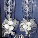 Cintas y rosas en las patas de los vasos.