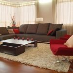 Sofá marrón y sillón rojo en la sala de estar