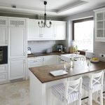 Cocina con muebles blancos y encimera oscura.