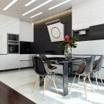 Mesa y sillas negras en una cocina blanca