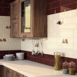 Diseño de cocina con azulejos blancos y burdeos.