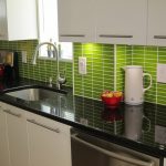 La combinación de muebles blancos y delantal verde claro.