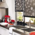 Cortinas oscuras en el interior de una cocina clara.
