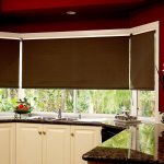 Cortinas oscuras y muebles de cocina brillantes.