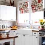Muebles blancos y cortinas de colores en la cocina.