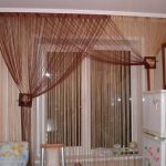 Cortinas de filamentos en la ventana de la cocina.